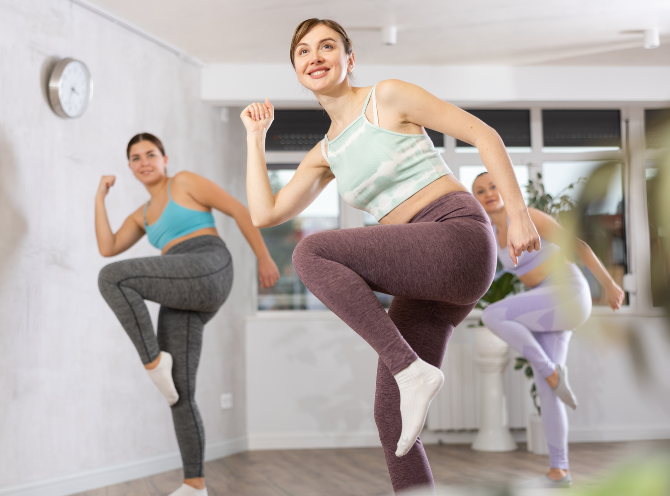 Happy woman training vigorous zumba in fitness studio